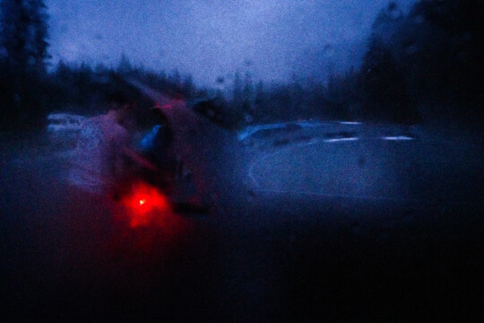 Widok auta przez zalaną deszczem szybę