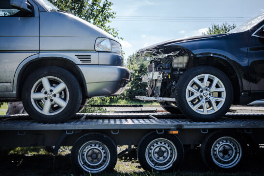 Copyright: Agnieszka Budzyńska Dwa samochody na lawecie. Jeden z rozbitą maską.
