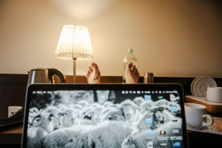 Copyright: Agnieszka Budzyńska Nogi na stole, na których leży otwarty komputer