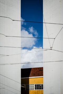 Copyright: Agnieszka Budzyńska Żółty dom pomiędzy dwoma słupami mostu w Lizbonie