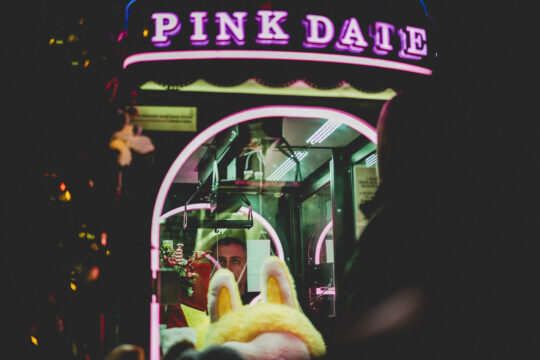 Copyright: Agnieszka Budzyńska Osoba wpatrzona w urządzenie PinkDate na Jarmarku Bożonarodzeniowym w Warszawie