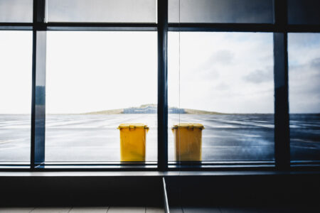 Copyright: Agnieszka Budzyńska Odbity żółty śmietnik w szybie na lotnisku na Pico