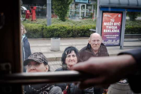 Ludzie czekający na tramwaj na przystanku