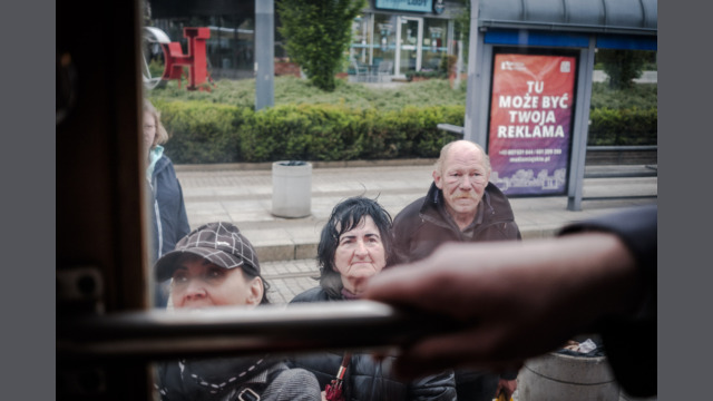 Ludzie czekający na tramwaj na przystanku