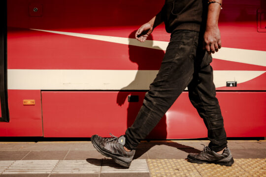 Cień człowieka, nogi i tramwaj