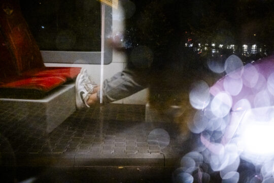 Osoba trzymająca nogi na siedzeniu tramwaju