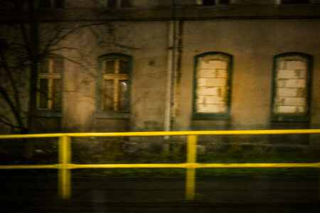 Dom z zamurowanymi oknami i żółta barierka