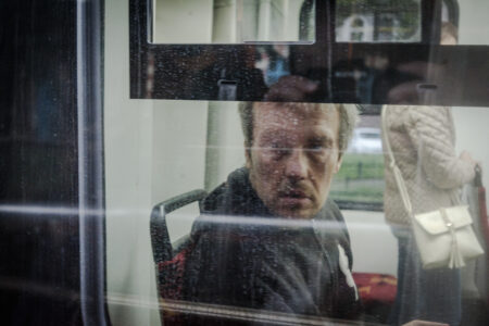 Mężczyzna patrzący przez szybę tramwaju