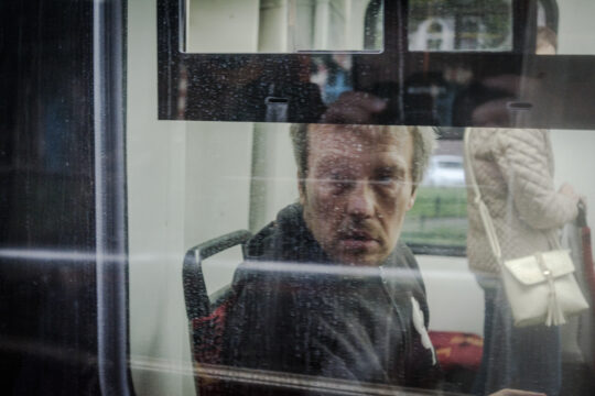 Mężczyzna patrzący przez szybę tramwaju