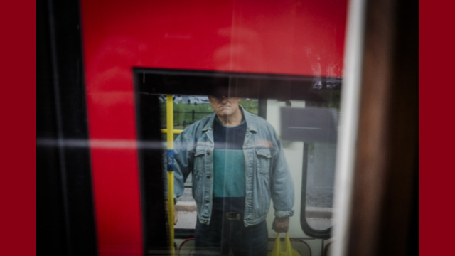 Osoba stojąca przed tramwajem w reklamówka w dłoni