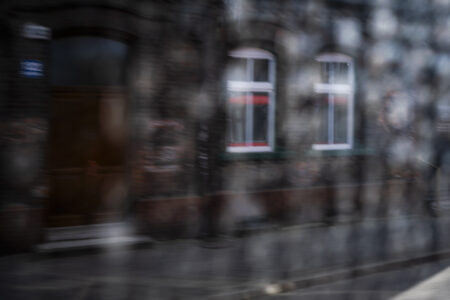 Okna kamienicy rozmazane przez szybę