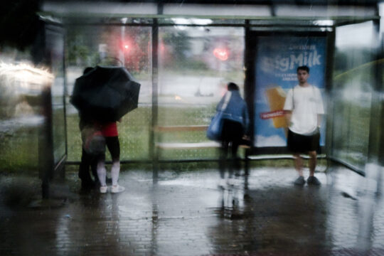 Osoby w deszcze czekające na przystanku. Katowice Załęże