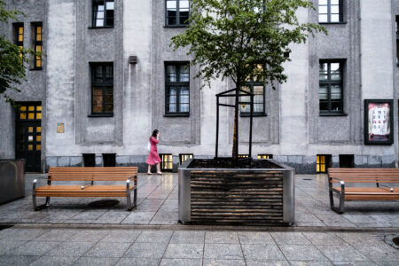 Pani w sukience idąca w deszczu pod Teatrem Śląskim