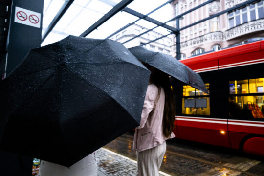 Dwie dziewczyny z wielkimi czarnymi parasolami i tramwaj